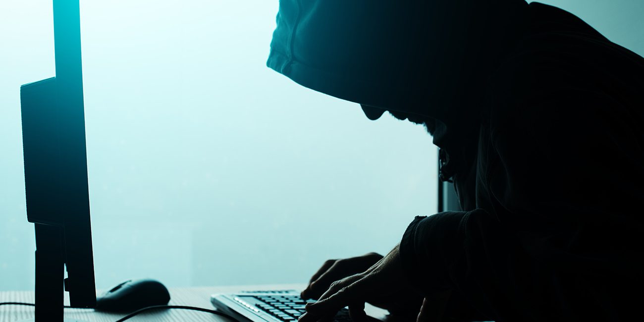 Silhouette man at computer - hacker