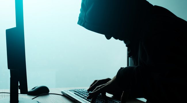 Silhouette man at computer - hacker