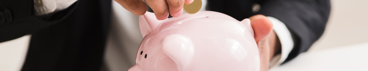 man putting a coin in a Piggy Bank