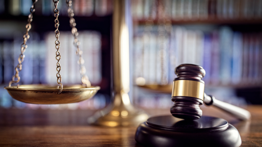 Gavel and Scales with book shelves in the background