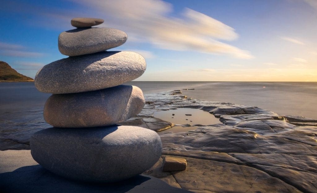 Rocks stacked on top of each other next to a large body of water
