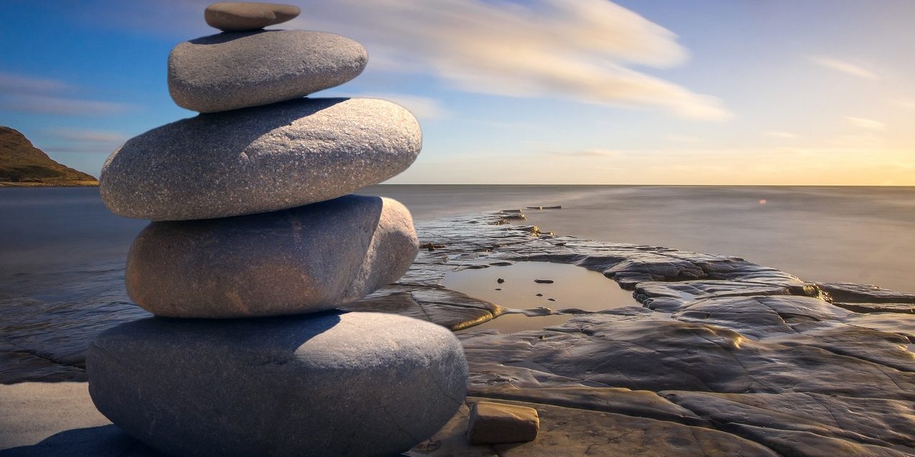 Rocks stacked on top of each other next to a large body of water