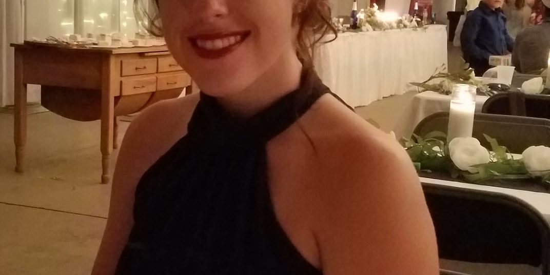smiling young woman wear a black dress at a fancy event