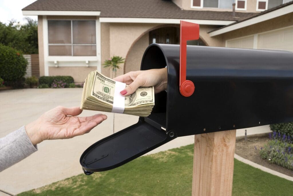 A stack of cash being pulled from a mailbox, illustrating the suspicious and illegal tactics used by phantom debt collectors demanding untraceable payments.