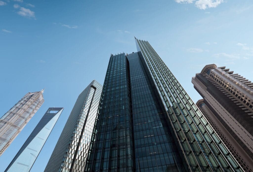 upertall financial district skyscrapers towering under a blue sky, representing the banking institutions targeted in the text phishing surge.